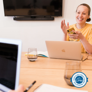 A woman sitting at a table with a laptop.